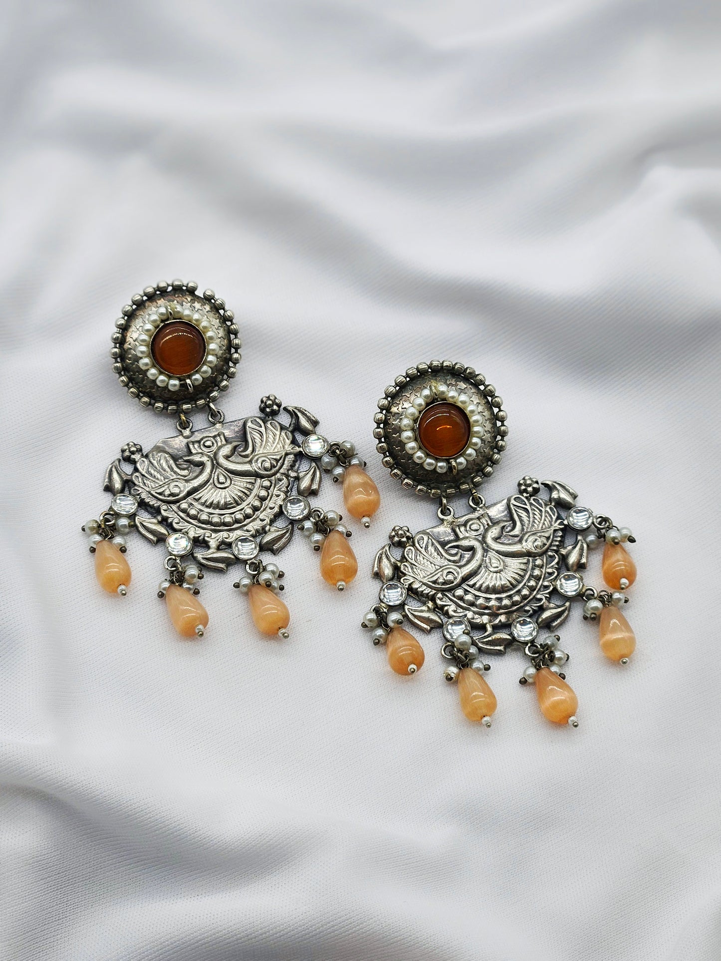 oxidised earring with cream pearl annd red stone in center 