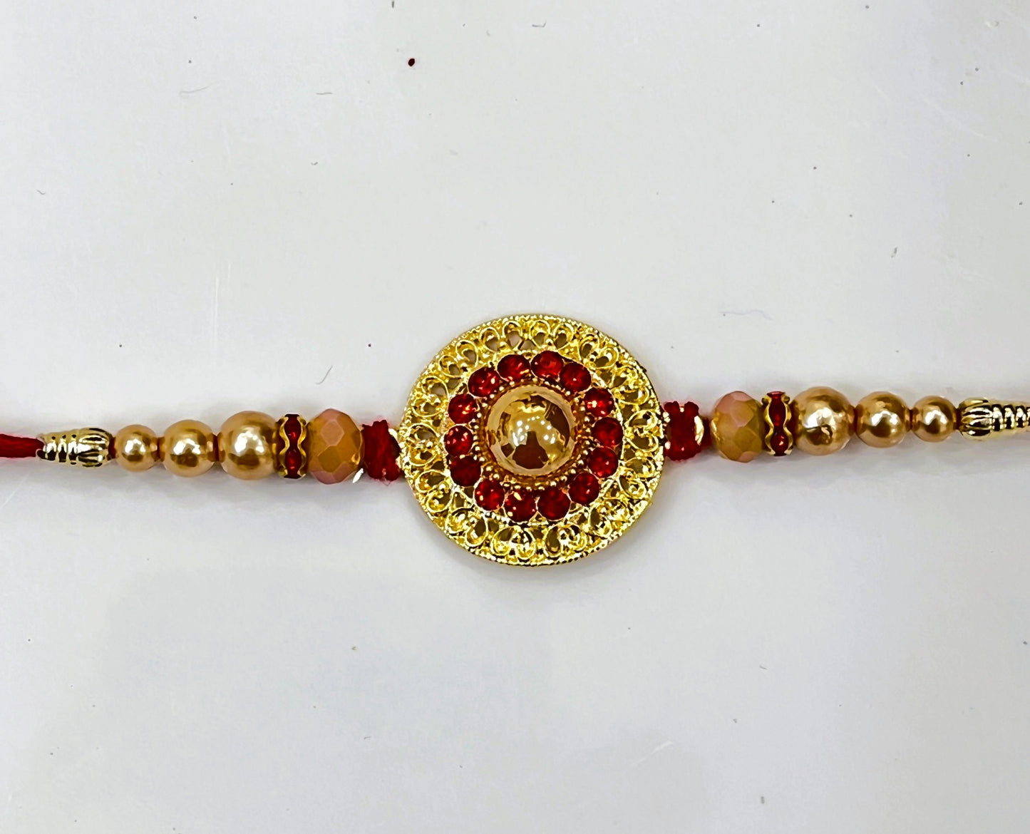 GOLD CIRCLE RED STONE RAKHI